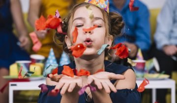 portrait-teenage-girl-blowing-confetti-her-birthday